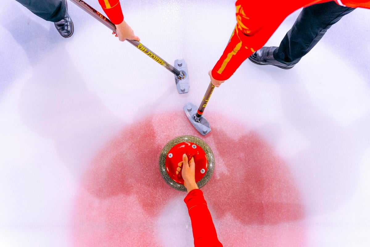 Curling stone and brooms