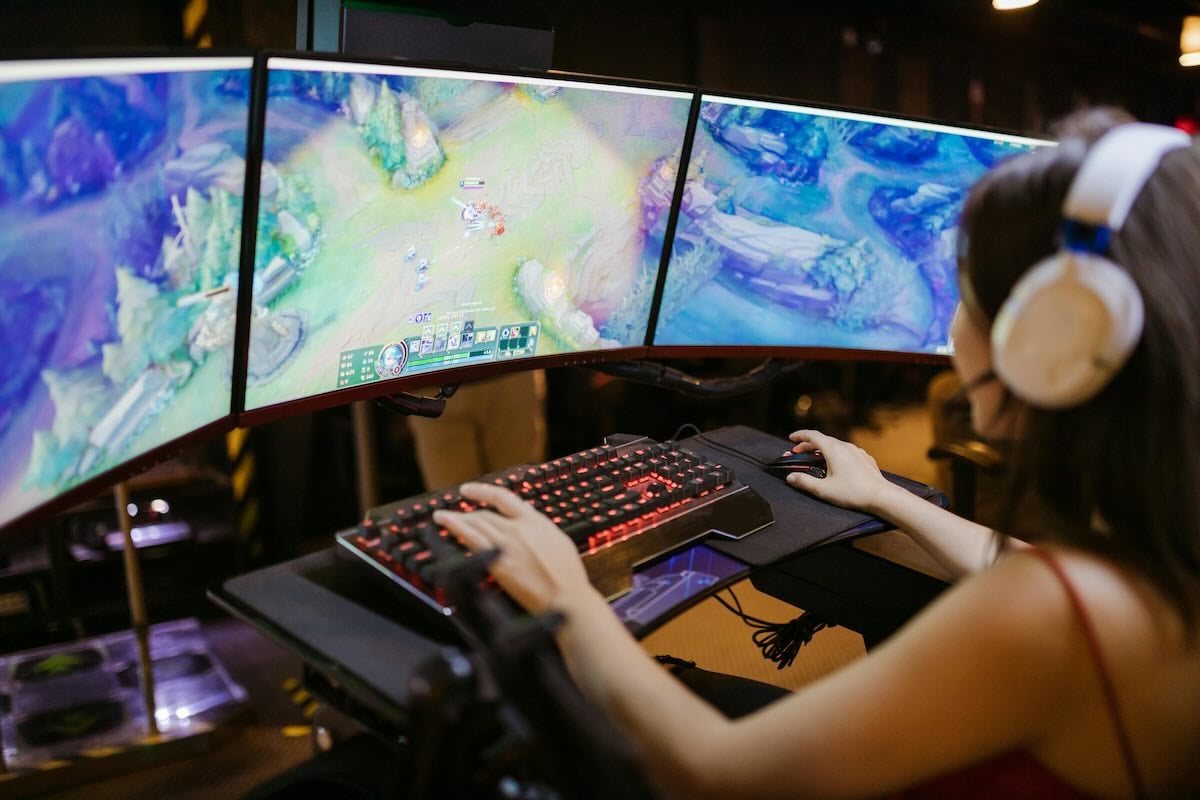 A woman using multiple monitors to play a game
