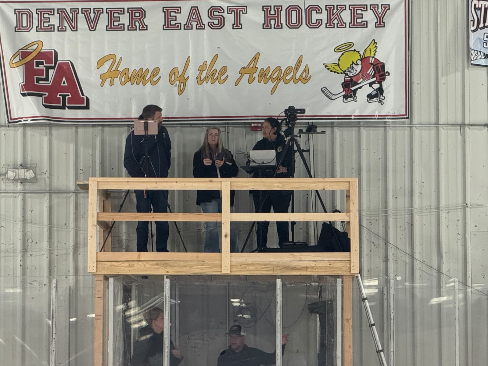 Summer and another hockey parent coordinate streaming duties at center ice, sharing the responsibility of bringing youth hockey to families watching remotely