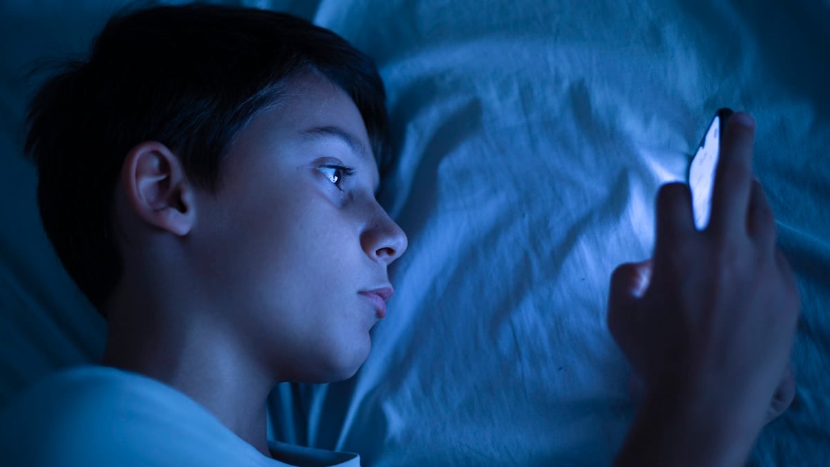 A child using a device in bed