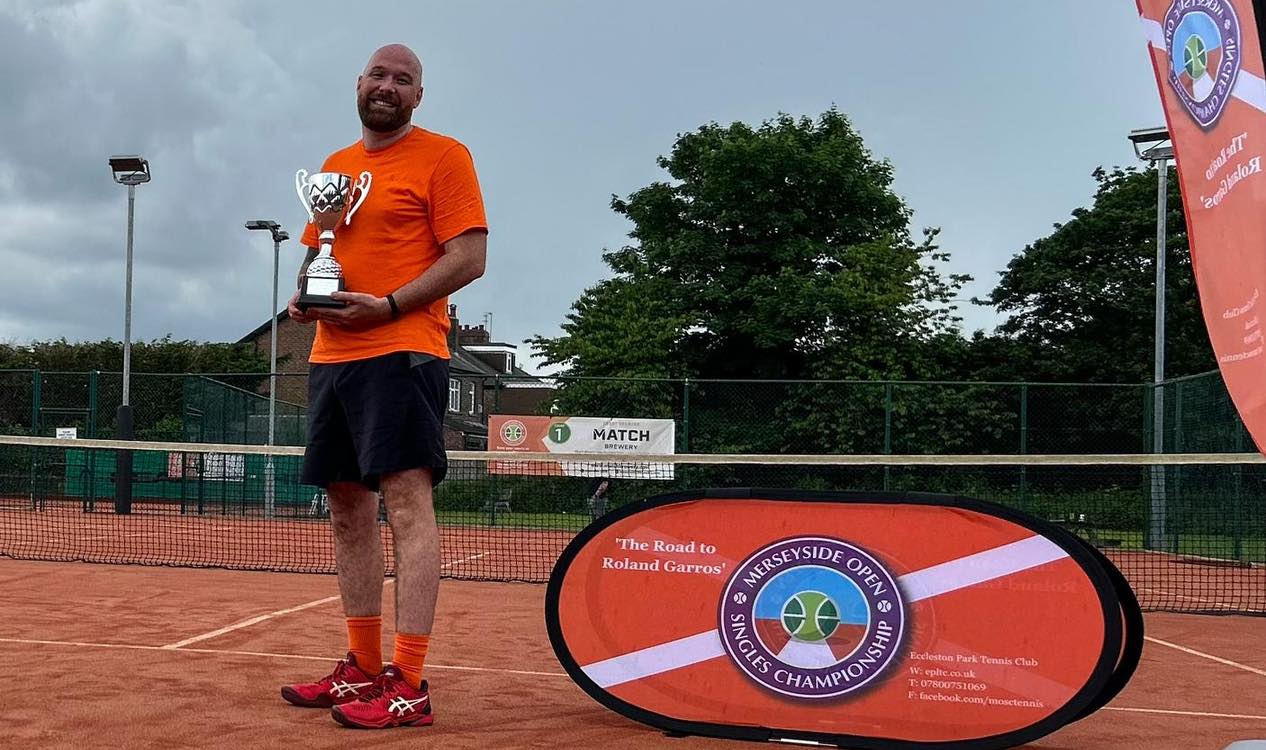 Tournament champion celebrating with trophy at Merseyside Open Singles Championship