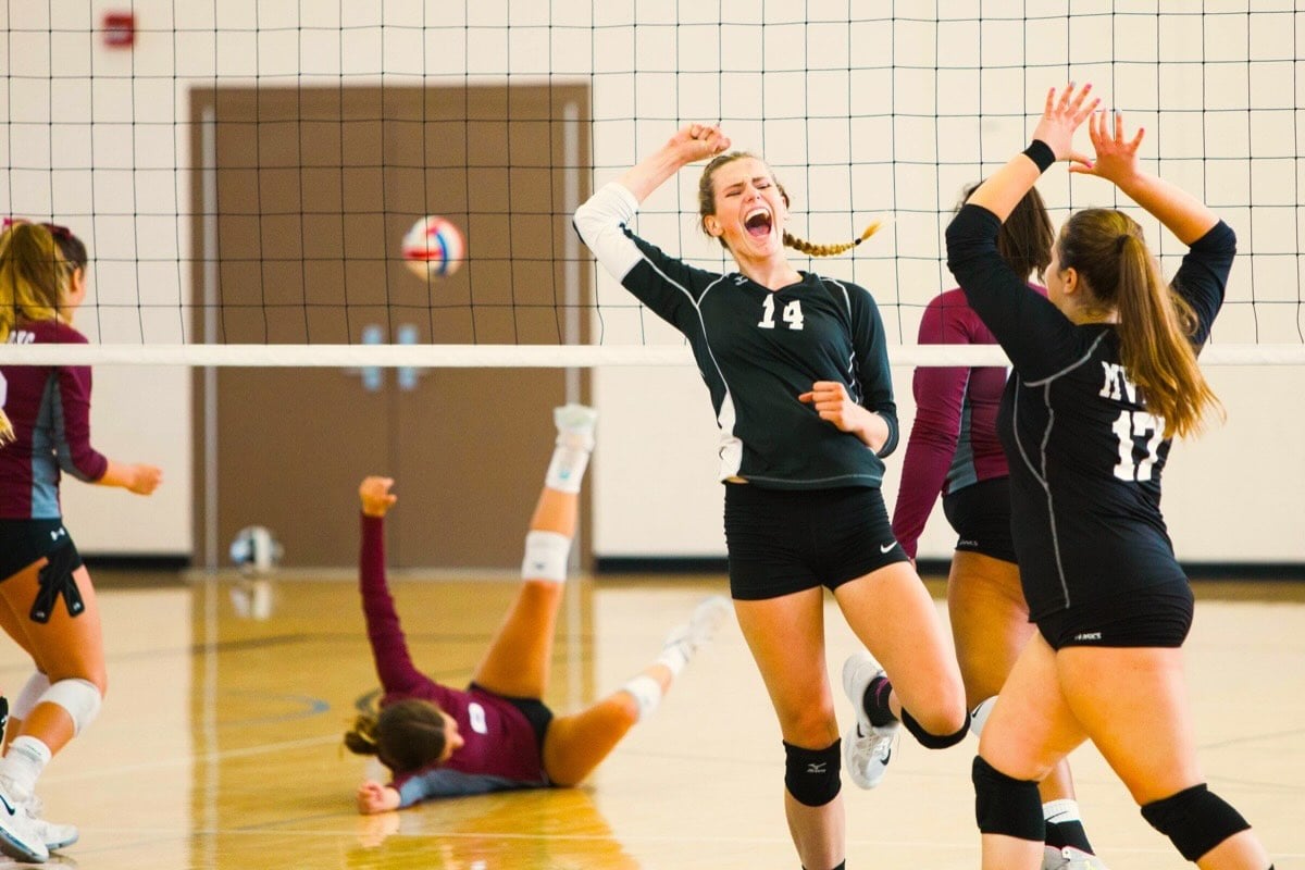 A female team that has just scored in a volleyball game