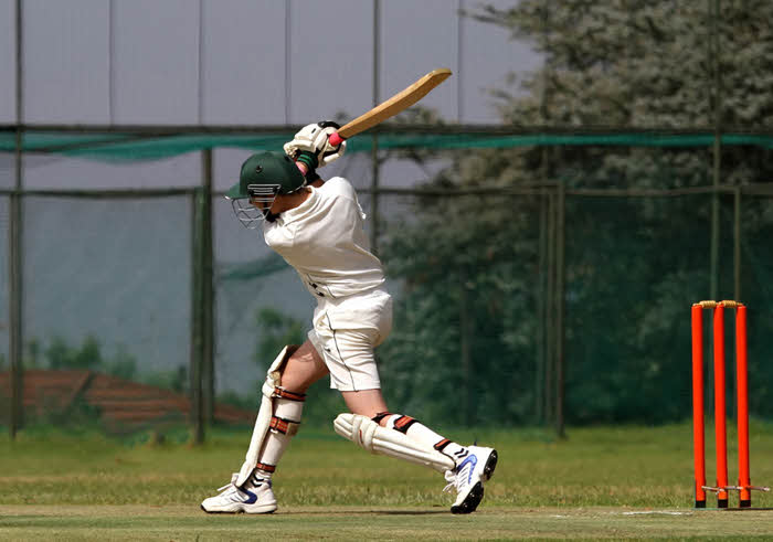 A scoreboard overlaid on a live-stream of a cricket match.